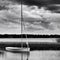 Sailboat anchored on lake during stormy day