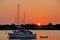 Sailboat anchored on river at sunrise