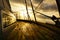 Sailboat with beautiful morning sky visible from side deck, in action on the water.