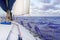 Sailboat bow with the tightened sail, sailing in the wind, with the sea in the background. Concept of water tourism. Sailing a