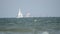 Sailboat and cargo ship in the sea