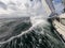 Sailboat fights storm and waves in open sea. Concept of travel, adventure, risk and adrenaline