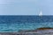 Sailboat glides across the bright ocean