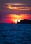 Sailboat and lighthouse on dramatic sunset