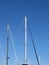 Sailboat masts in the marina against a blue summer sky