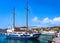 Sailboat moored at jetty of Greek island. Whitewashed houses waterfront. Summer sunshine, vacations, adventures. Mykonos