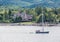 Sailboat Motoring Past Tudor Mansion