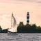 Sailboat moving past the big lighthouse