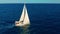 Sailboat in the ocean. White sailing yacht in the middle of the boundless ocean. Aerial view.