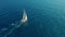 Sailboat in the ocean. White sailing yacht in the middle of the boundless ocean. Aerial view.