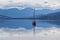 Sailboat reflecting in calm waters of Huon River, Tasmania