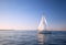 Sailboat reflecting in water as it is leaving Channel Islands harbor in Oxnard California USA