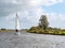 Sailboat sailing in canal called Jeltsesloot near Heeg, Friesland, Netherlands