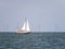 Sailboat sailing on lake IJsselmeer and windturbines of windfarm Urk, Netherlands