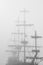 Sailboat sailing on a serene ocean partially obscured by a mysterious fog