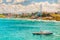 A sailboat sails in front of a Colorful hillside in Puerto Rico beach front