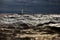 Sailboat in sea at stormy weather, blurred background, stormy clouds sky, sail regatta, reflection of sail in the water