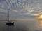 Sailboat on the sea in sunset with textured cloudy sky