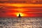 Sailboat silhouette in front of a large setting sun