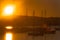 Sailboat silhouettes, magnificent golden warm sunset in Ibiza marina.