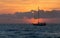 Sailboat sunset fantasy with a silhouetted boat sailing along it