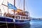 Sailboat under Greek flag moored at jetty of typical Greek island. Schooner. Summer day sunshine, vacations and