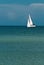 Sailboat, in windy, sunny day sailing along the horizon