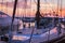 Sailboat with wooden deck standing in marine at sunset