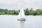 Sailboat yacht team sailing with full sails on river lake