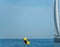 Sailboat, yellow buoy and gas tanks in the background with text space