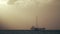 Sailboats against cargo ship at sea sunset