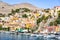 Sailboats and colorful neoclassical houses in harbor town of Symi Symi Island, Greece