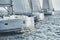 Sailboats compete in a sailing regatta at sunset, sailing race, reflection of sails on water, white color of sails, boat