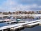 Sailboats covered with snow and moored at a dock in a Marina after a winter snow storm.