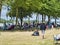 Sailboats fans enjoy big outdoor entertainment event. Open air festival Picnic. Big group of people on grass waiting for armada