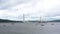 Sailboats stand in the roadstead in the bay of Peter the Great against the background of the Russian Bridge