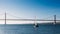 Sailboats with white sails on the Tagus River, 25 of April Bridge, Lisbon, Portugal