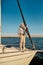 Sailing alone. Vertical shot senior man standing on the side of a sailboat or yacht deck floating in sea on a sunny day