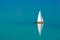 Sailing boat on a calm lake with reflection in the water. Serene scenic reflection recreational landscape