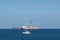 Sailing boat, drilling ship and tanker on ocean horizon -