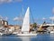 Sailing boat exiting the harbor with sails unfurled