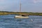 A sailing boat moored in the River Glaven, Norfolk at sunset