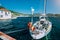 Sailing boat moored up in the picturesque Greek town. Mediterranean landscape of green hills, mountains and clear water