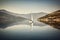 sailing boat passing through calm waters, with majestic mountains in the background