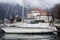 A sailing boat at the pier, a stone house on the shore and a lighthouse in the Bay. Mountains in fog