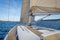 Sailing boat teak deck and hoisted sails, view from the cockpit to the bow.