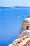 Sailing Boats Near Caldera Volcanic Slopes of Santorini Oia or Ia Village in Greece. With Traditional Pale Dome Orthodox Greek