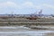 Sailing and fishing boats lying on the sea floor at low tide.