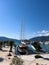 Sailing and motor yachts stand at the pier with palm trees against the backdrop of mountains