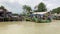 Sailing passing by fishing boat docking at river. Traditional pier of fishing ship harbor